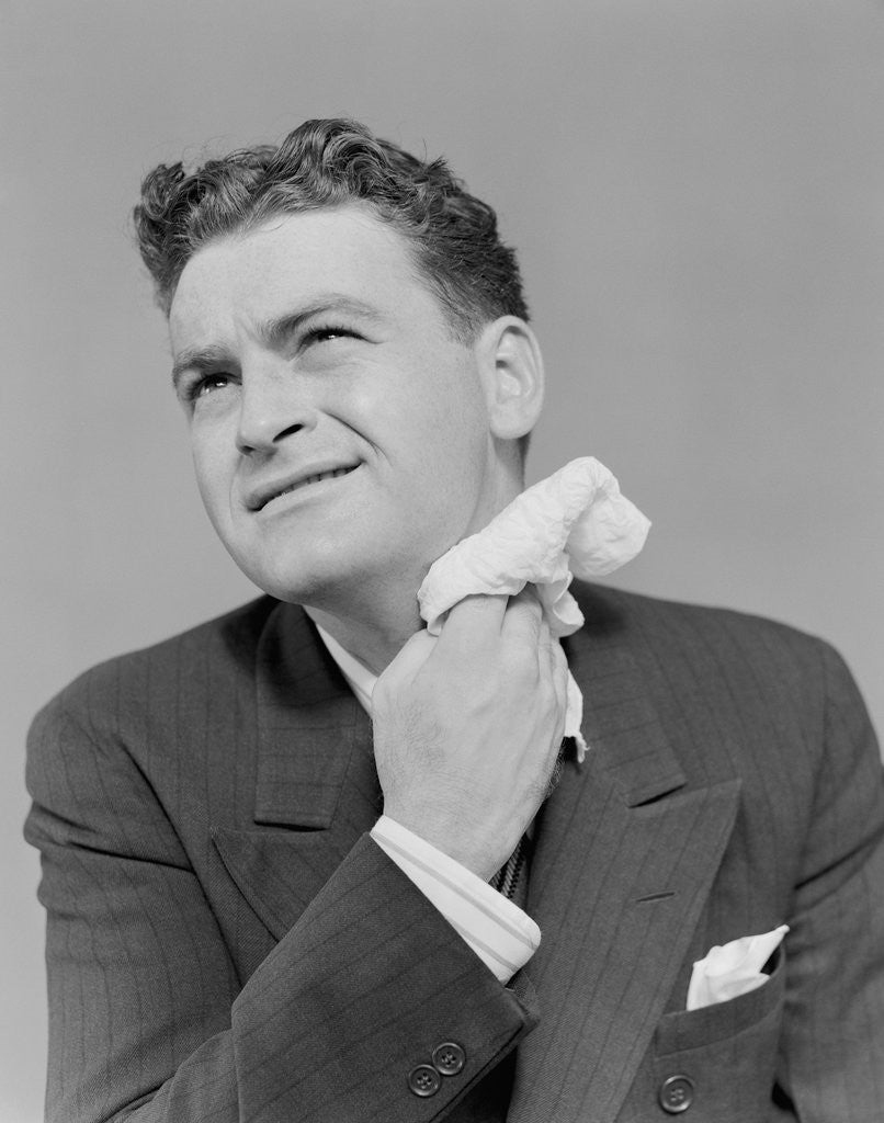 Detail of Man uncomfortable grimace sweating wiping neck with handkerchief by Corbis