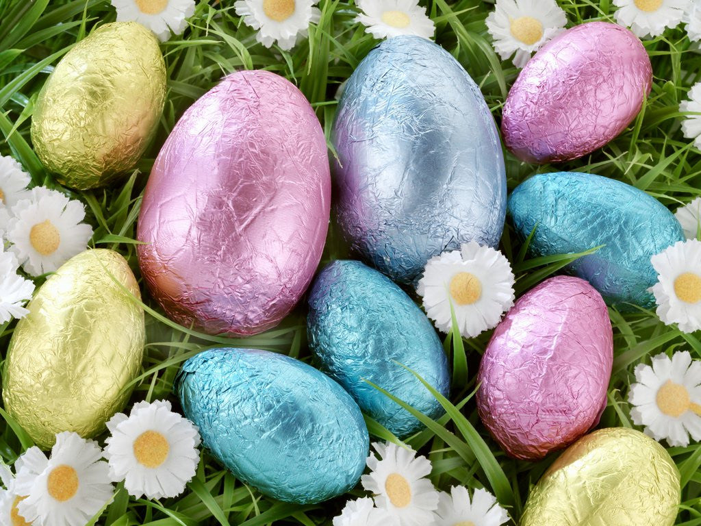 Detail of Chocolate Easter eggs in coloured foil in grass by Anonymous