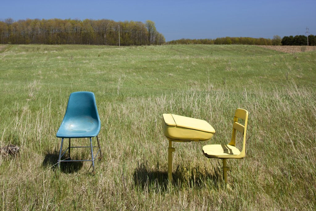 Detail of Abandoned school desk and chairs in farmer's field by Corbis