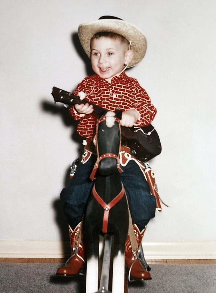 Little boy cowboy plays guitar while riding his horse ca. 1956 posters prints by Corbis