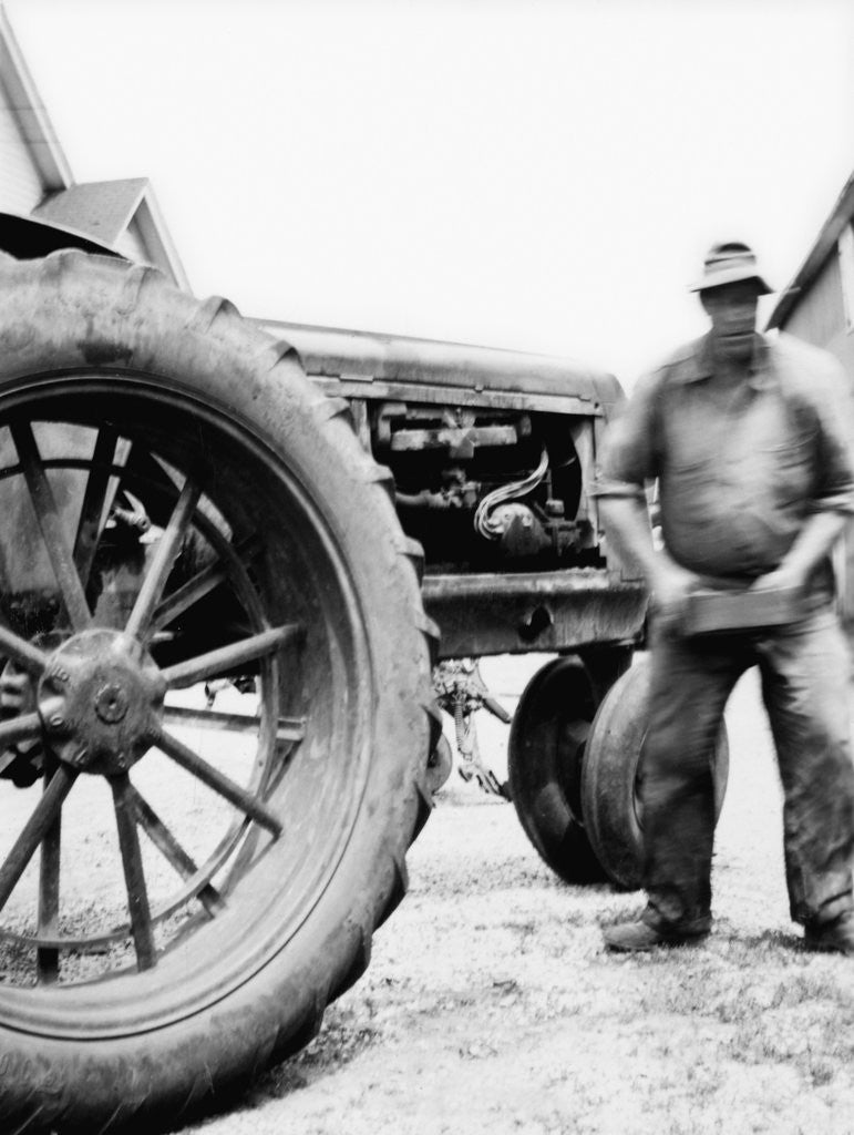 Detail of Farmer is a blur of activity working on his tractor, ca. 1938 by Corbis