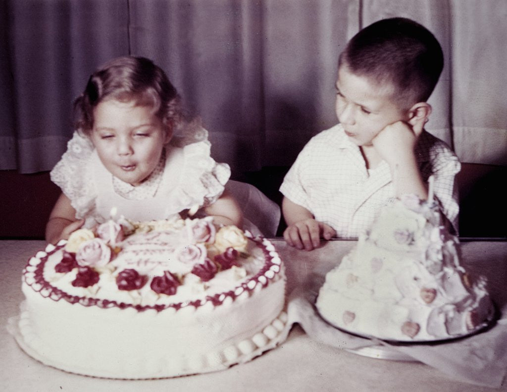 Detail of Brother watches his sister blow out candles on birthday cake, ca. 1956 by Anonymous