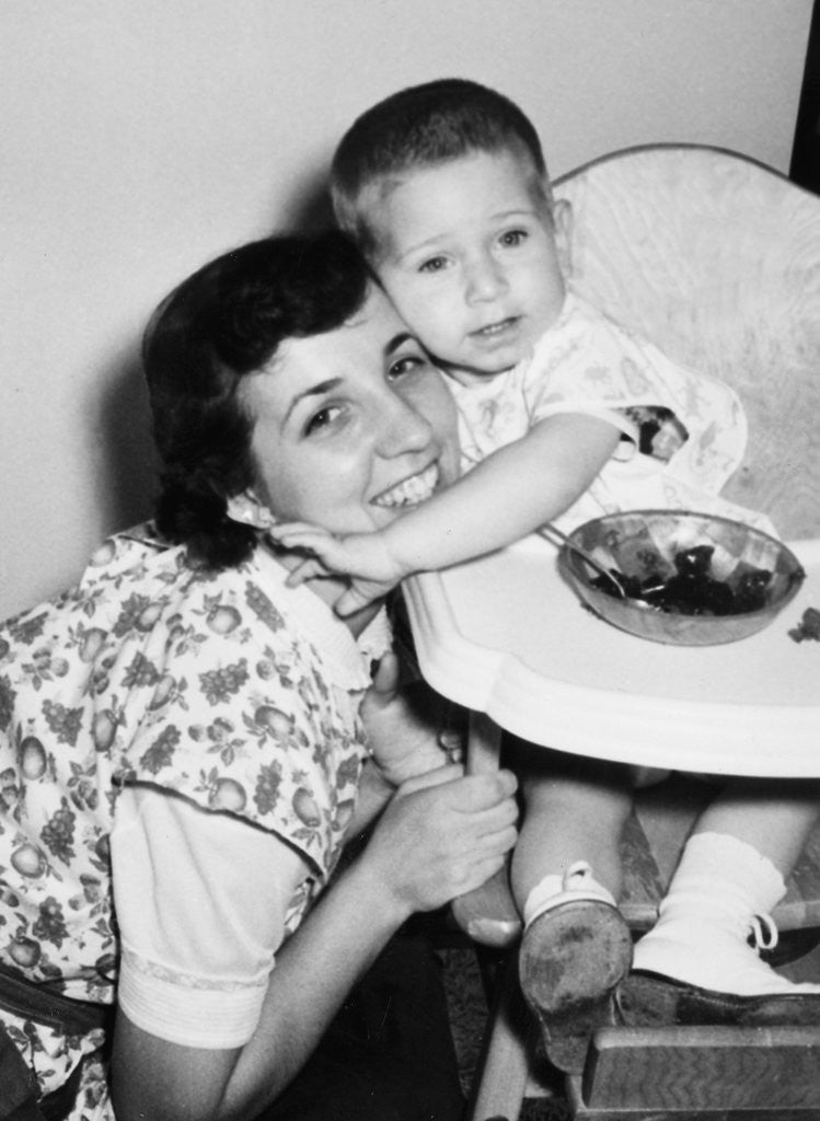 Detail of Baby boy hugging mother at dinner time, ca. 1953 by Anonymous