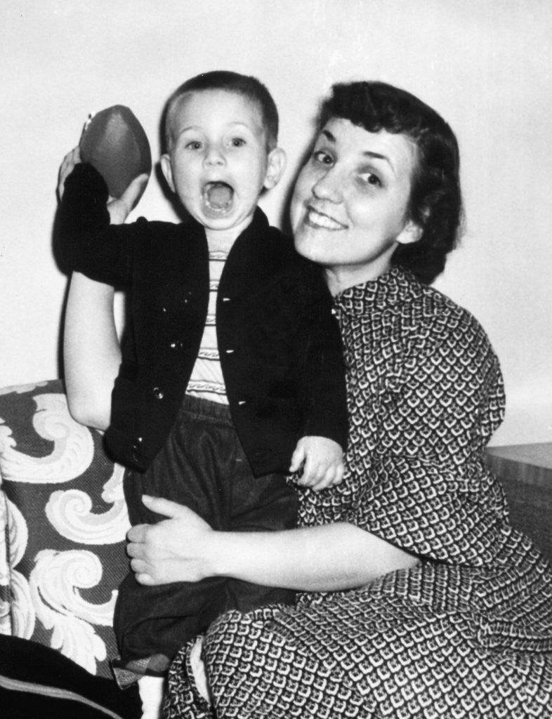 Detail of Little boy holding football with his mother, ca. 1955 by Anonymous