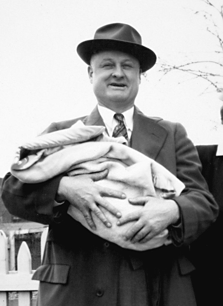 Detail of Mature man holds a baby, ca. 1950 by Anonymous