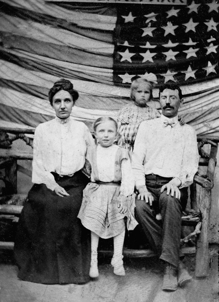 Detail of Family pose in front of American Flag, ca. 1898 by Corbis