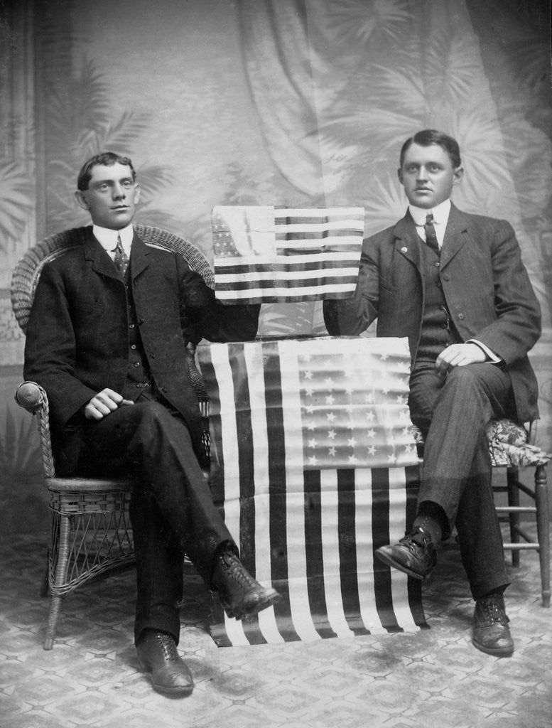 Detail of Two men pose with American flags, ca. 1895. by Anonymous