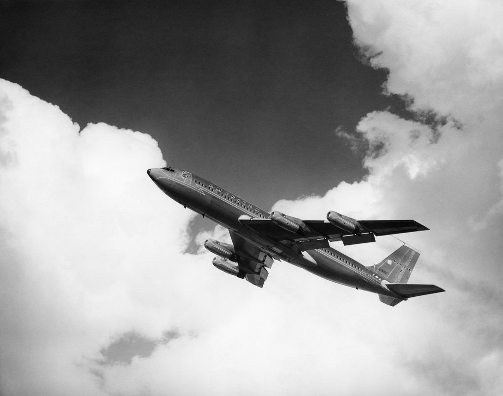 Detail of 1960s american airlines a-707 jet ascending through clouds by Corbis
