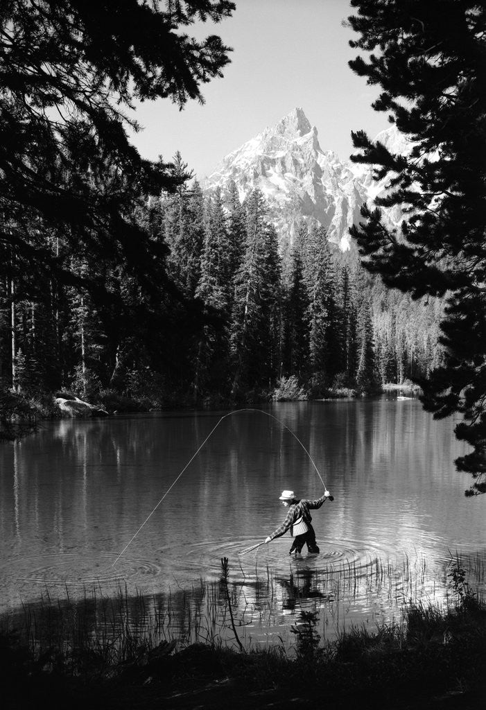 Detail of 1960s man fishing holding net and rod wyoming grand teton national park string lake by Corbis