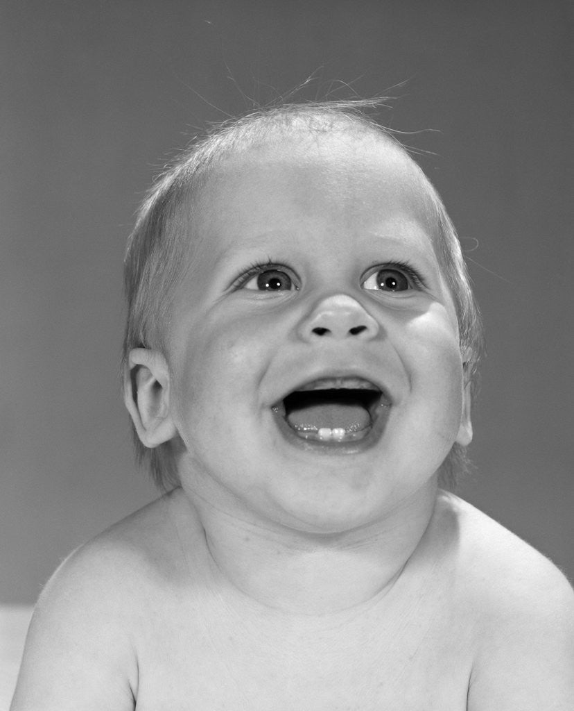 Detail of 1960s portrait close-up of smiling baby boy showing first two teeth in bottom gums by Anonymous