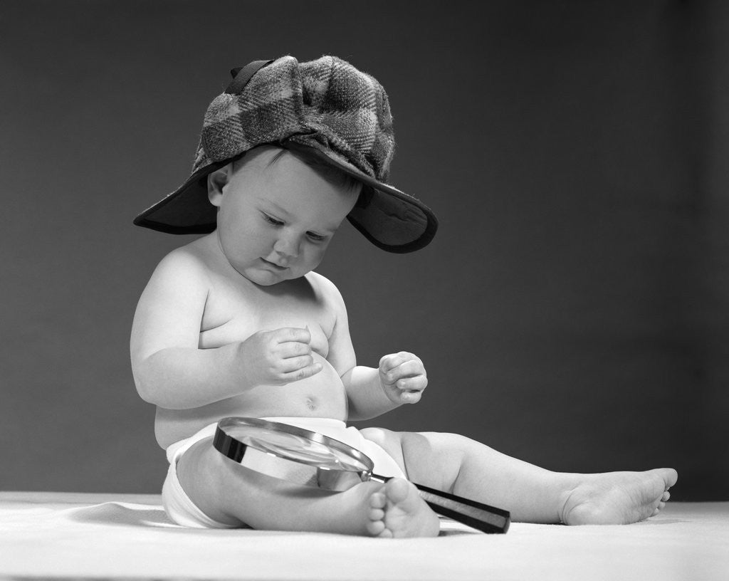 Detail of 1960s baby in diaper wearing sherlock holmes deerstalker style double-billed cap with magnifying glass resting on leg inspecting a clue by Anonymous