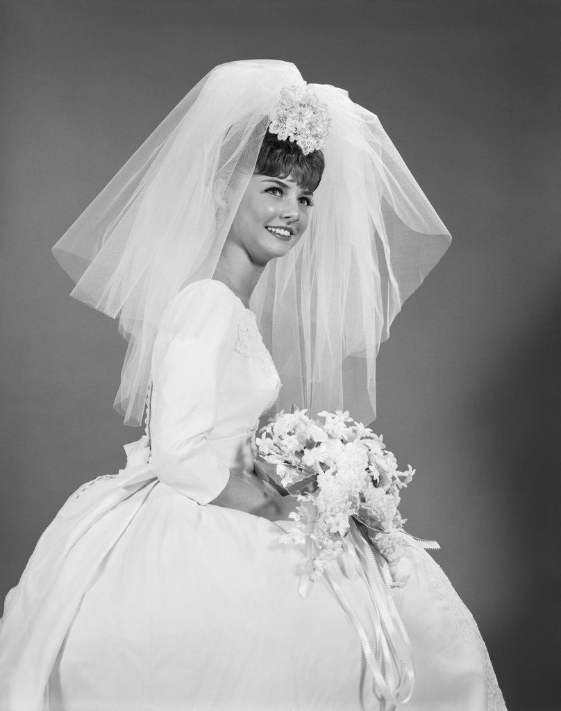 Detail of 1960s bride portrait in wedding dress veil bridal bouquet by Anonymous
