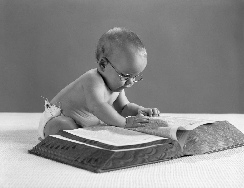 Detail of 1960s baby wearing glasses looking for a word in big dictionary by Anonymous