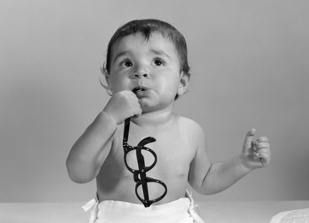 Detail of 1960s baby in diaper chewing on eyeglasses by Anonymous
