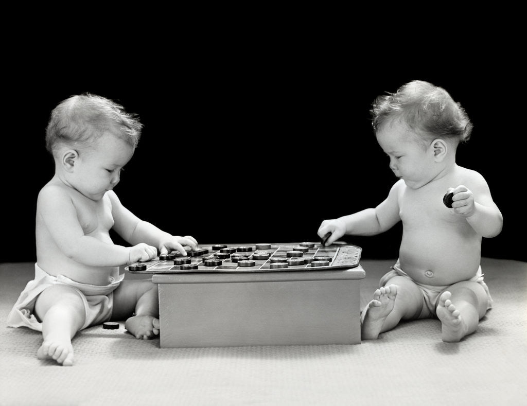Detail of 1930s 1940s twin babies playing game of checkers together studio by Corbis
