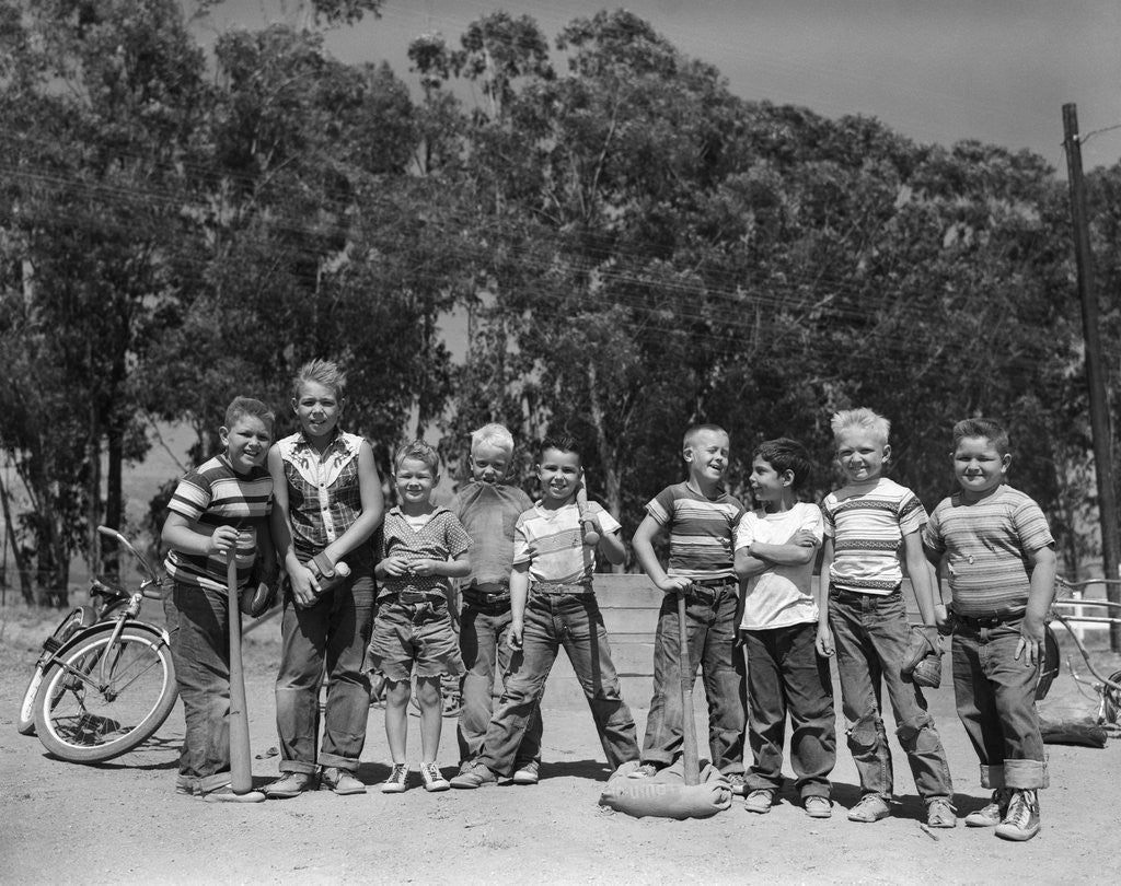 Detail of 1950s line-up of 9 boys in tee shirts with bats & mitts facing camera by Corbis