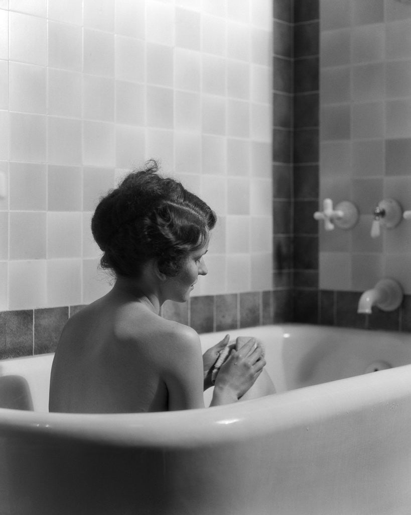 Detail of 1920s 1930s woman sitting in bath tub by Corbis