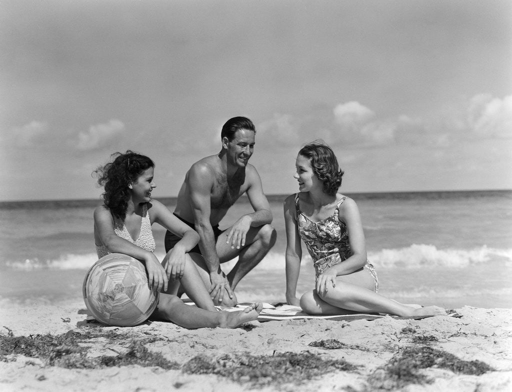 Detail of 1930s 1940s two women one man in bathing suits sitting on beach by Anonymous