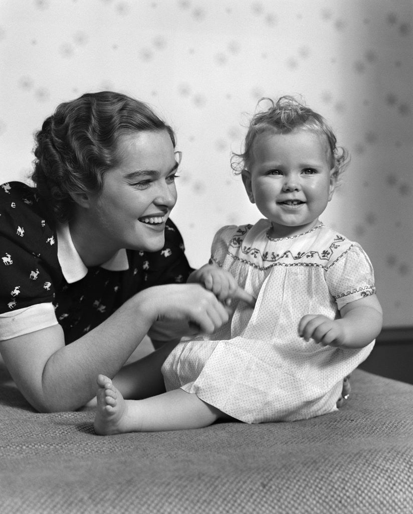 Detail of 1930s smiling mother and happy child looking at camera by Anonymous