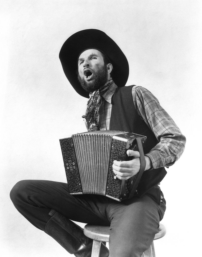 Detail of 1930s cowboy playing accordion & singing by Corbis