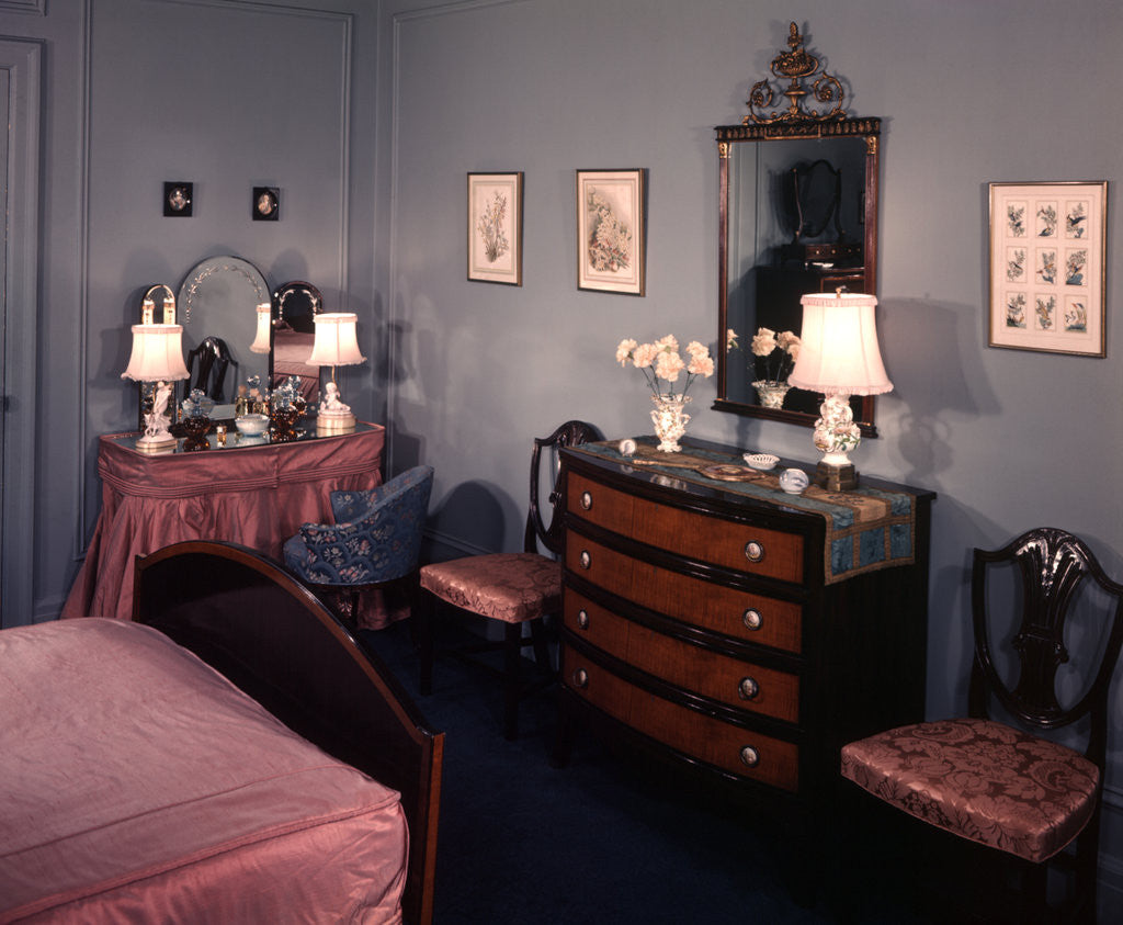 Detail of 1930s 1940s bedroom with blue walls pink bedspread and skirted vanity table by Corbis