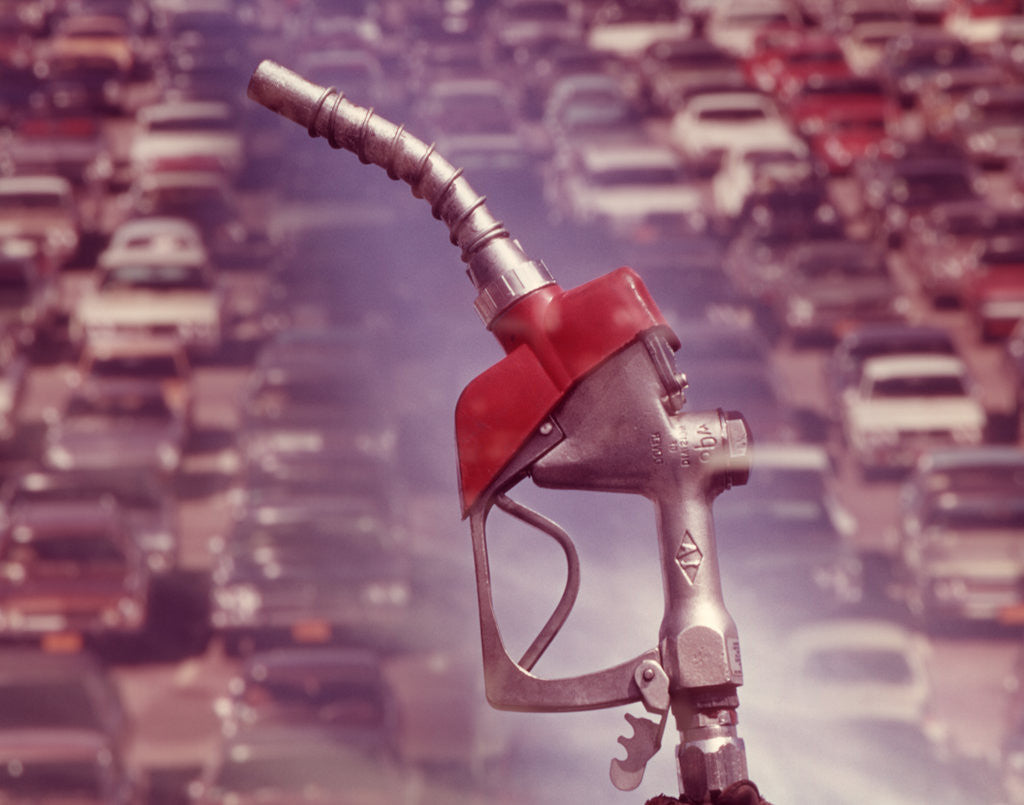 Detail of 1970s nozzle of gasoline pump with traffic background by Anonymous