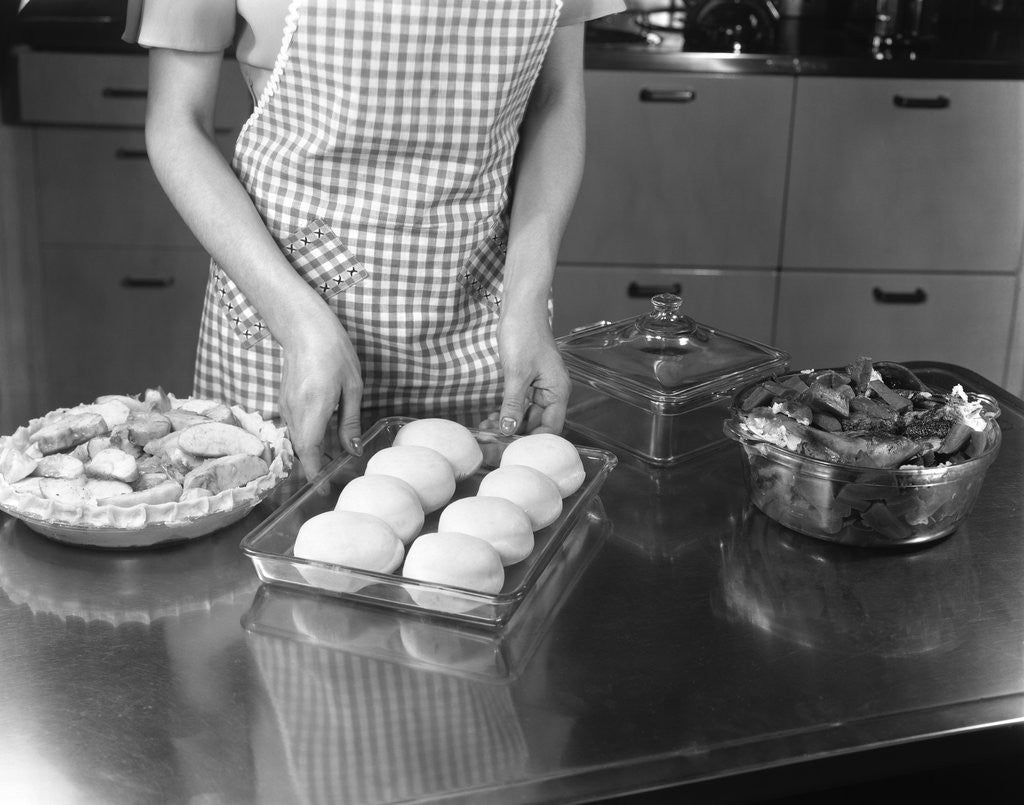 Detail of 1940s 1950s woman preparing dinner baking rolls and pie by Anonymous