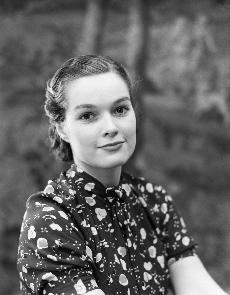 Detail of 1930s portrait of brunette woman wearing printed blouse half smile mona lisa like beautiful eyes looking at camera by Anonymous