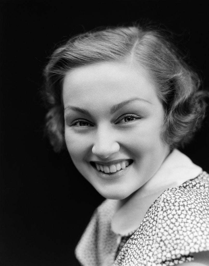 Detail of 1930s portrait happy young brunette woman wearing print blouse with white collar smiling looking at camera by Anonymous