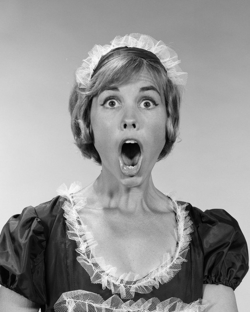 Detail of 1960s woman in maid uniform eyes and mouth wide open looking at camera by Anonymous