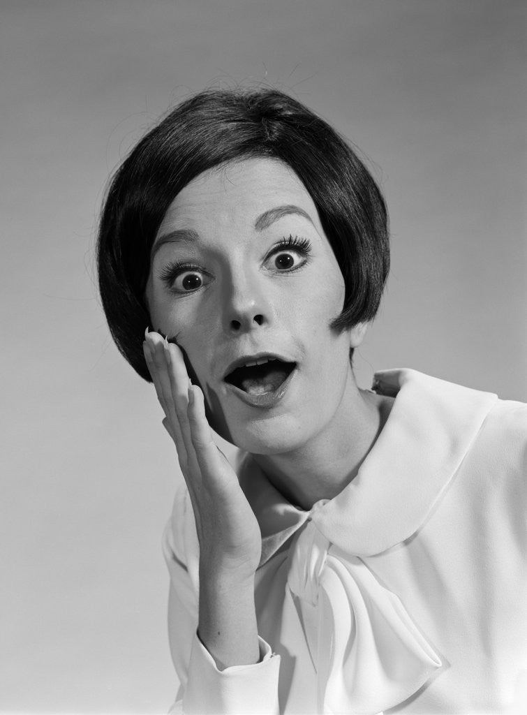 Detail of 1960s brunette woman mouth agape eyes wide hand to cheek funny face expression shock surprise anger amazed by Anonymous