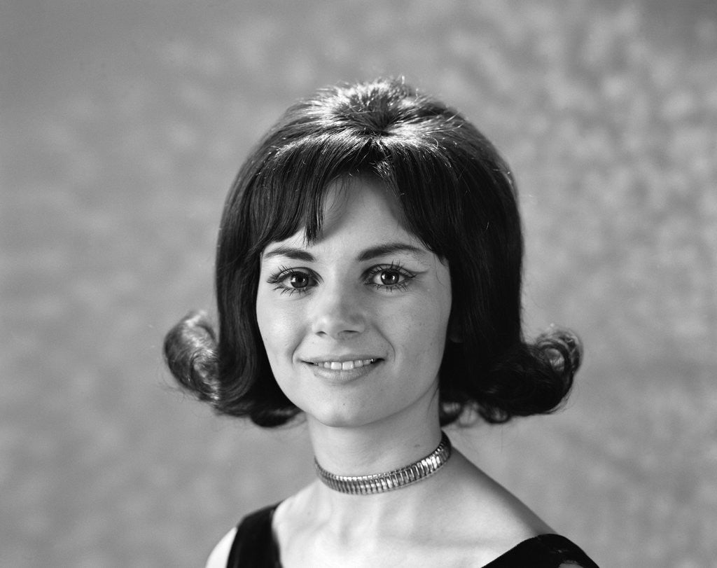 Detail of 1960s 1970s portrait smiling brunette woman flip hair style with bangs looking at the camera by Anonymous