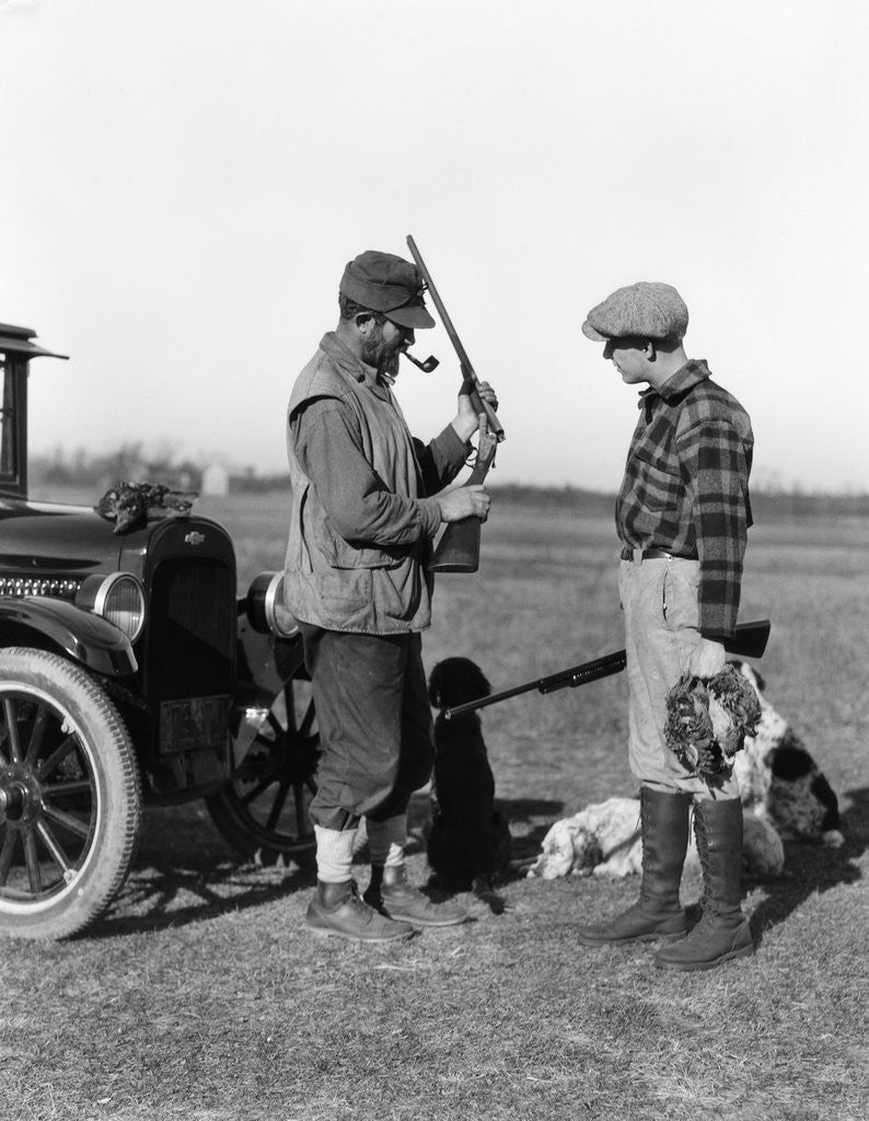 Detail of 1930s two men hunters by car looking at shotgun with dogs and brace of birds by Anonymous