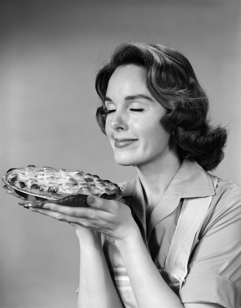 Detail of 1950s 1960s woman smelling aroma of freshly baked pie by Anonymous