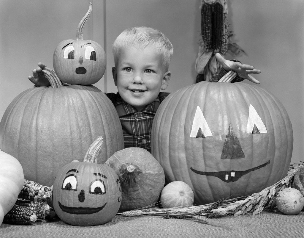 Detail of 1960s smiling blond boy surrounded by pumpkin patch jack-o'-lantern by Anonymous