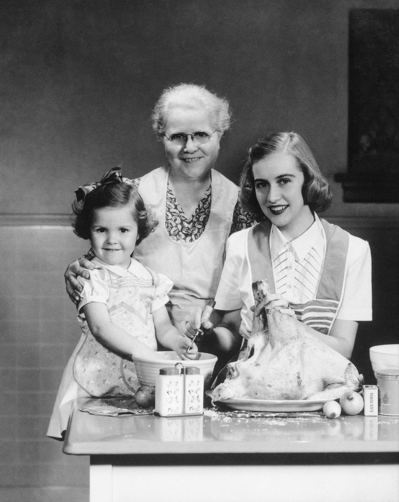 Detail of 1940s 1950s mother daughter grandmother stuffing turkey by Anonymous