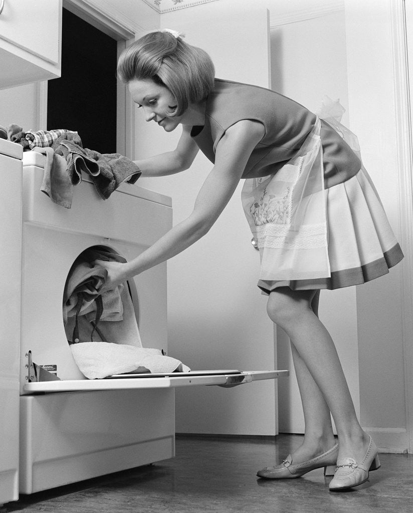 Detail of 1970s woman removing laundry from dryer by Corbis
