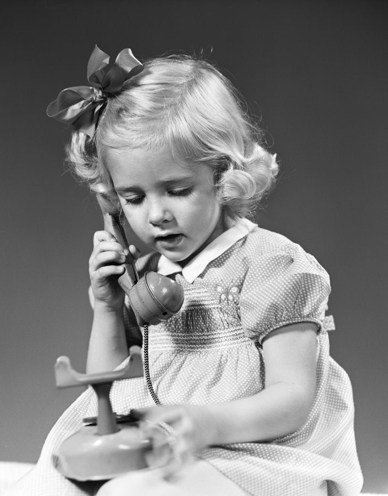 Detail of 1940s little blond girl talking on toy telephone by Anonymous