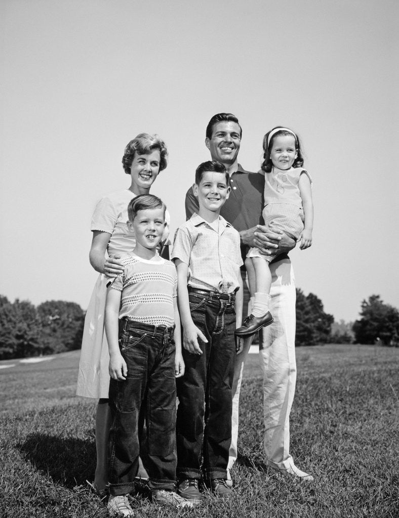 Detail of 1960s smiling family portrait standing on grass mother father three children by Anonymous