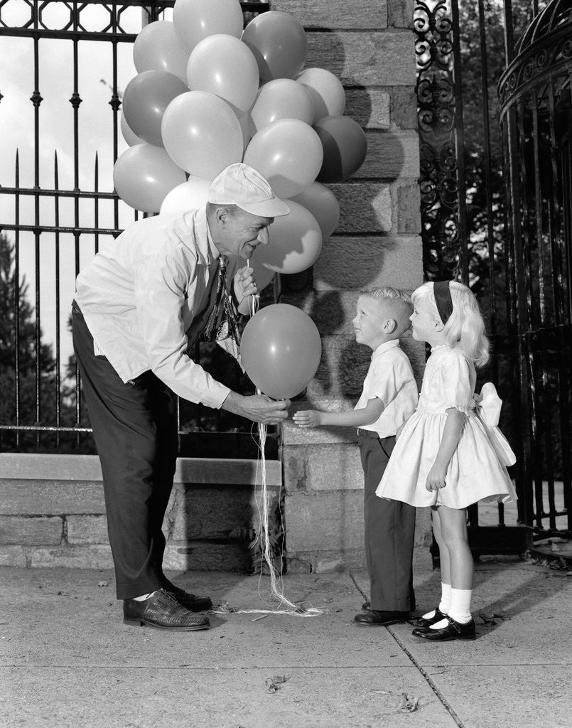 Detail of 1960s children boy girl getting a balloon from man by Anonymous