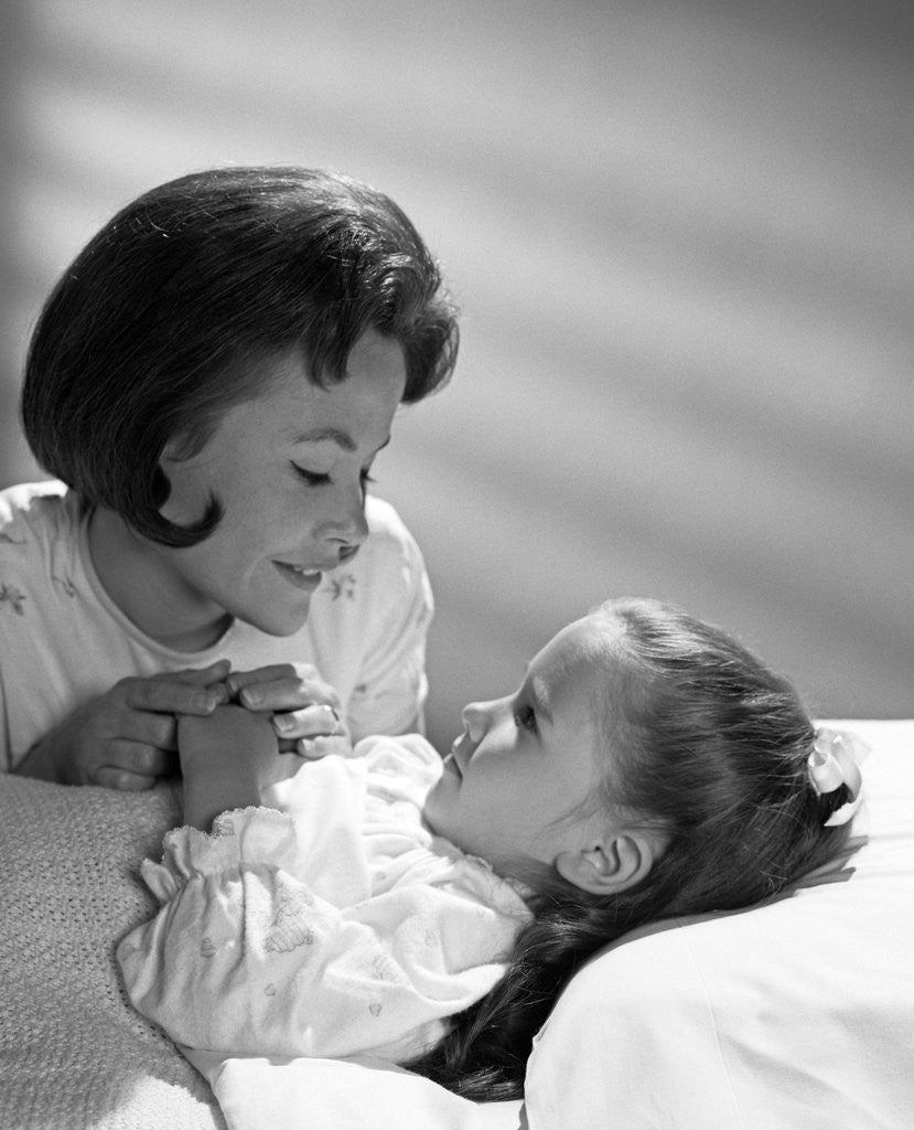 Detail of 1960s daughter with mother tucking into bed by Anonymous
