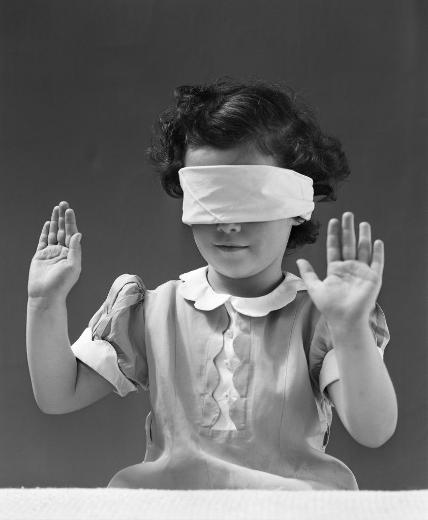 Detail of 1940s child wearing blind fold with hands up in the air by Anonymous