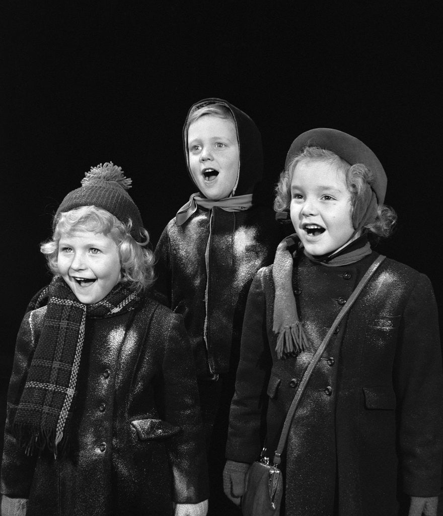 Detail of 1940s three children singing caroling by Corbis