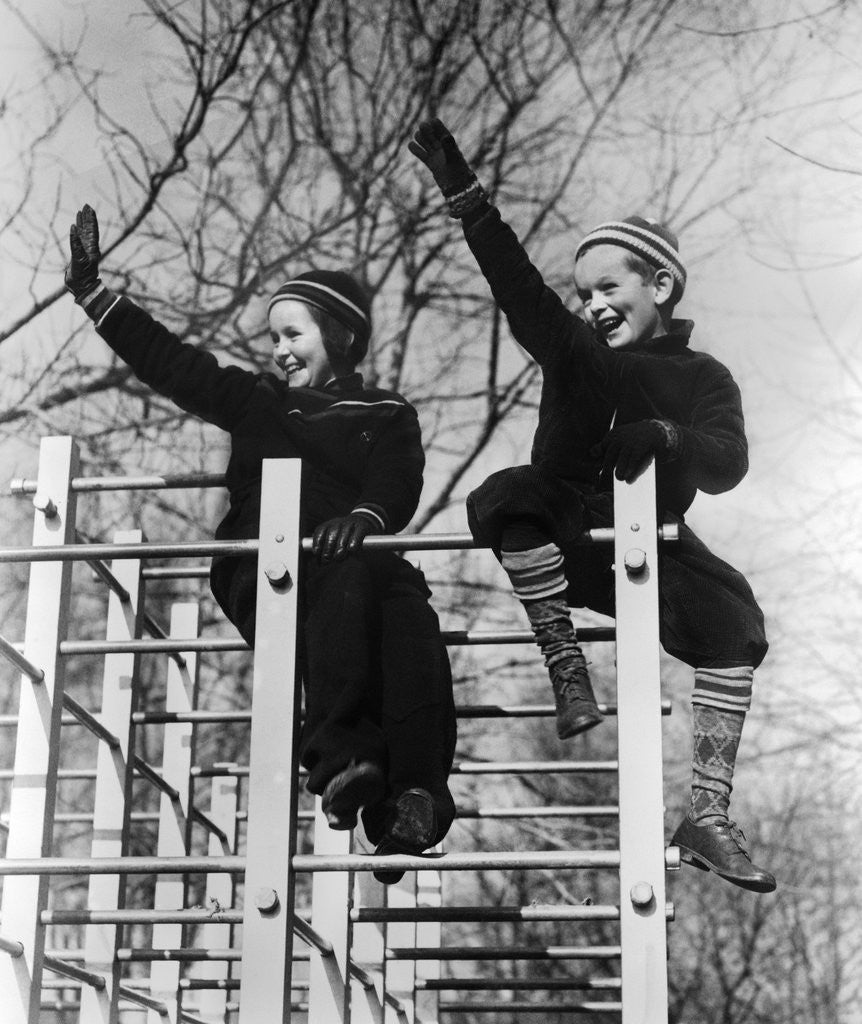 Detail of 1930s two children waving while sitting on playground equipment by Anonymous
