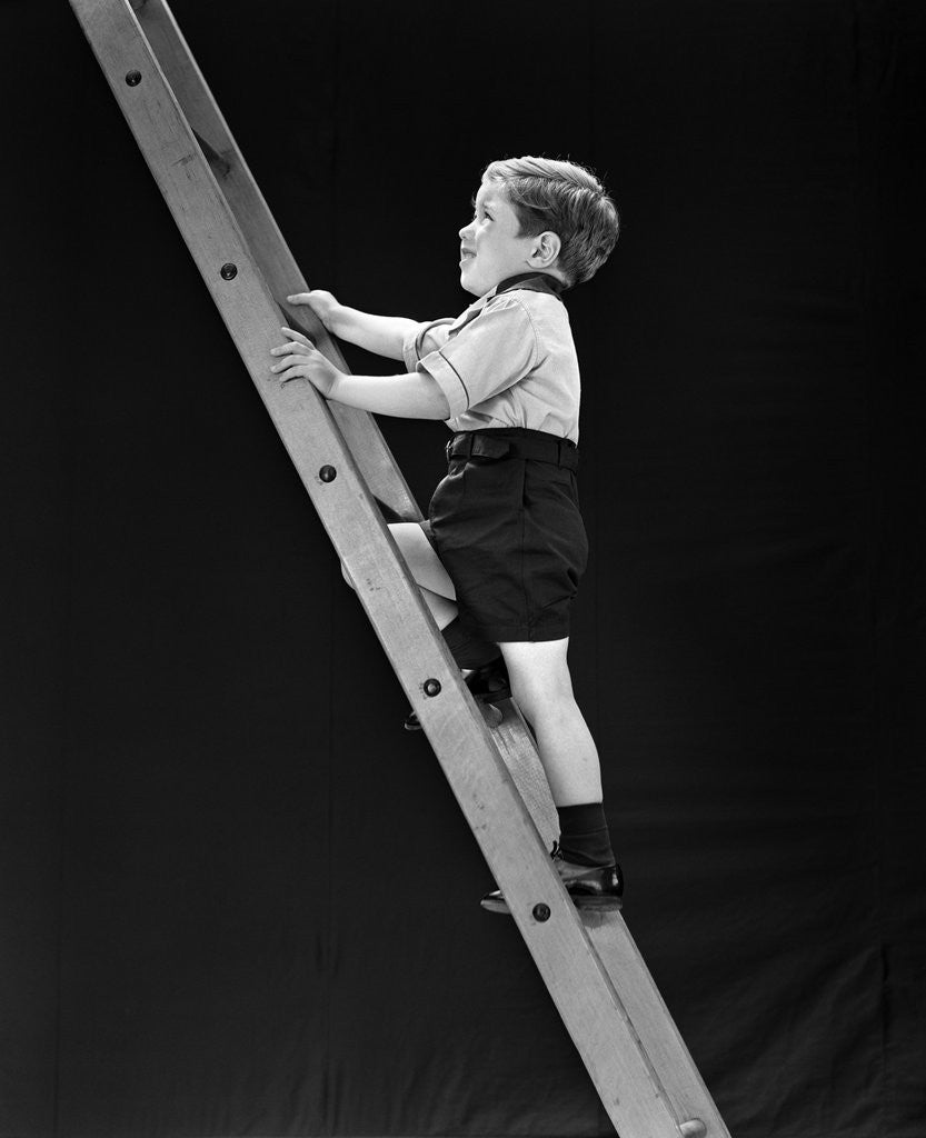 Detail of 1930s boy child climbing tall ladder by Corbis
