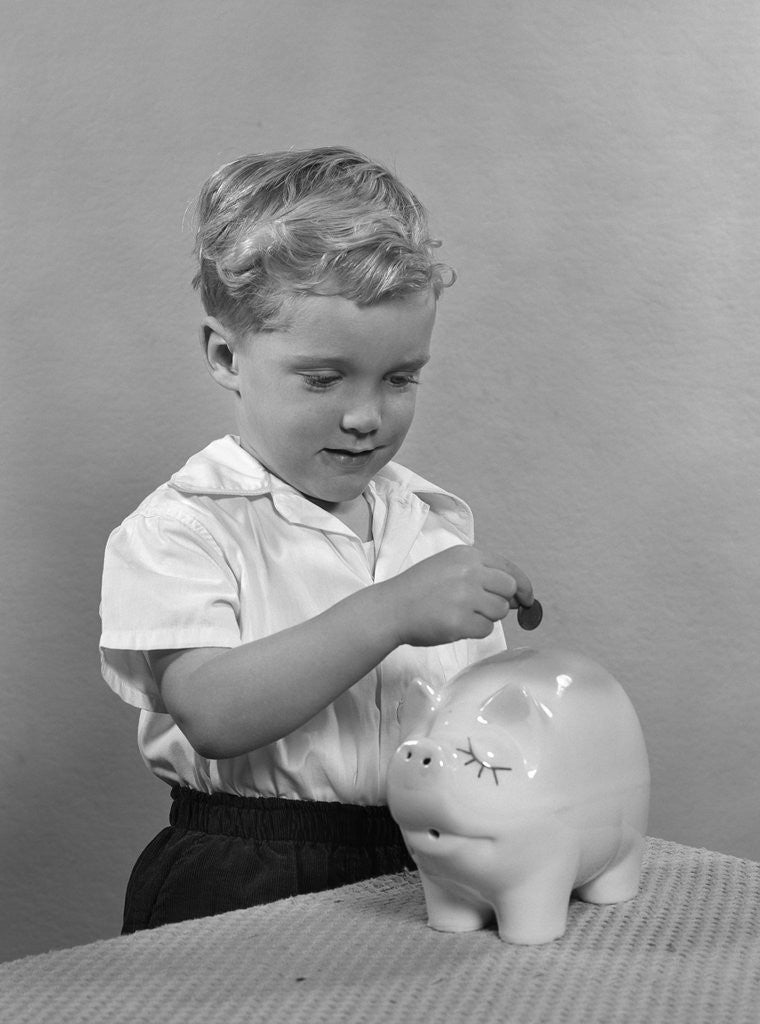 Detail of 1950slittle boy putting coin into piggy bank by Anonymous