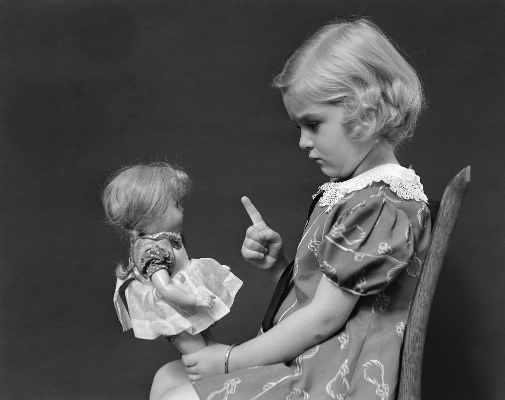 Detail of 1930s little blond girl scolding her doll pointing finger by Anonymous