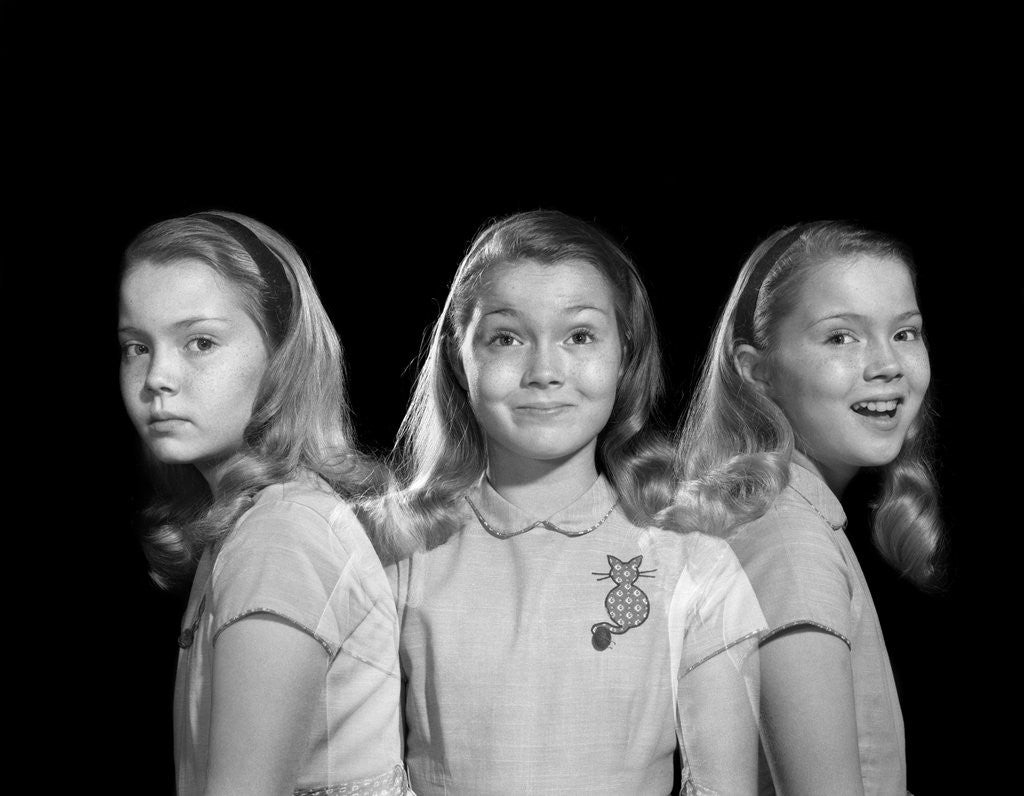 Detail of 1950s 1960s multiple exposure girl going from happy to sad three facial expressions looking at camera by Corbis