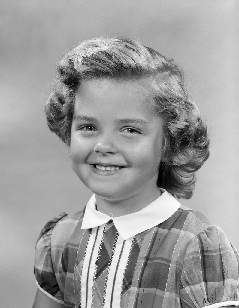 Detail of 1950s portrait smiling girl with white collar plaid dress looking at camera by Anonymous
