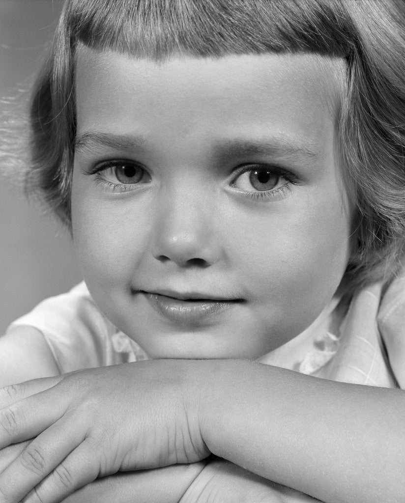 Detail of 1960s young girl posing with arms near face by Corbis